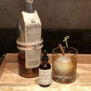 Basil Hayden whiskey, Woodford Reserve bitters, and a cocktail in a glass